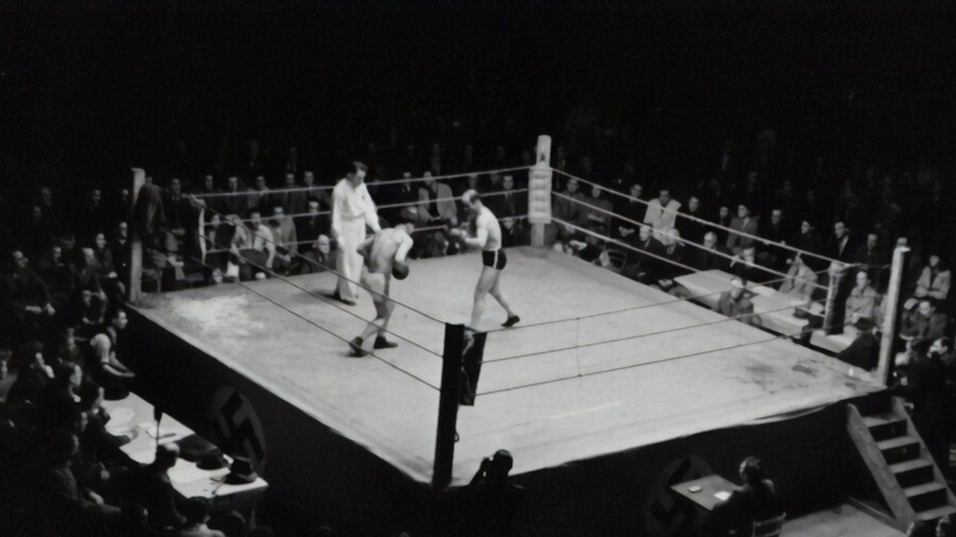 A boxing match with two male fighters in the ring